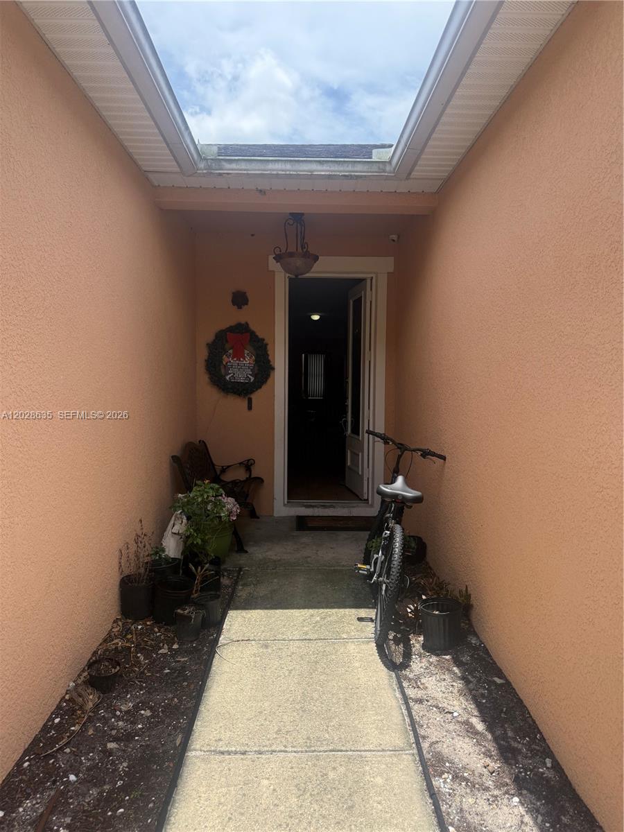 An outdoor entryway features a concrete walkway, a bicycle, potted plants, and a bench — 342 STAR SHELL DR, Tampa FL 33572, TAMPA, FL