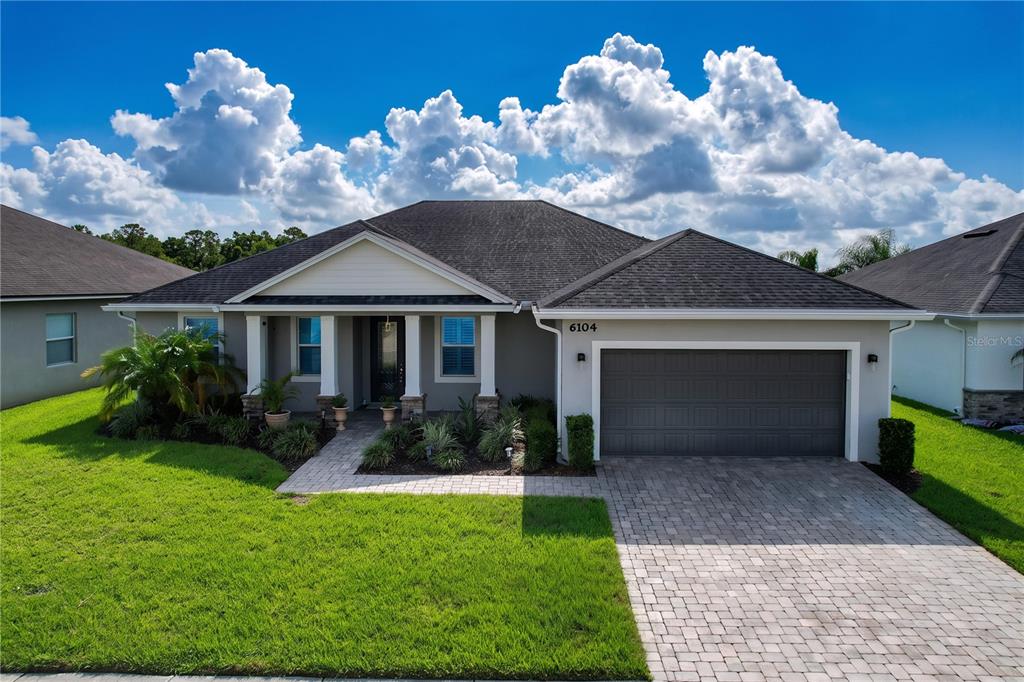 A single-story house with a gray exterior, a two-car garage, and a paved driveway — 6104 HIGHLANDS GRACE BOULEVARD, LAKELAND, FL