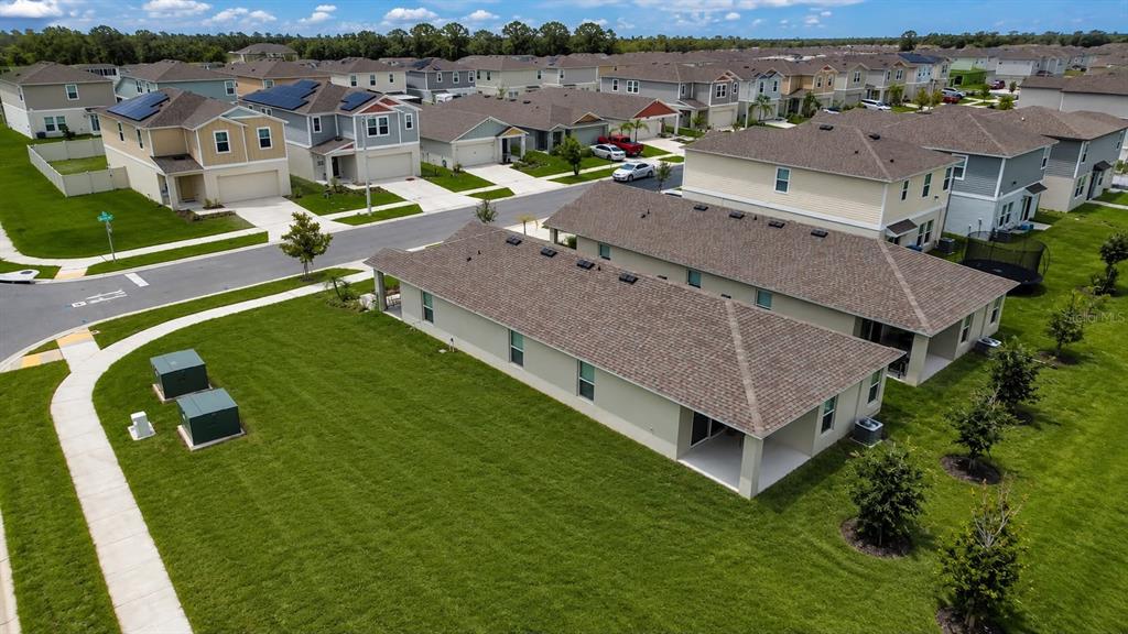 An aerial view shows a suburban neighborhood with single-family homes and manicured green lawns — 4904 MAINSAIL STREET, HAINES CITY, FL