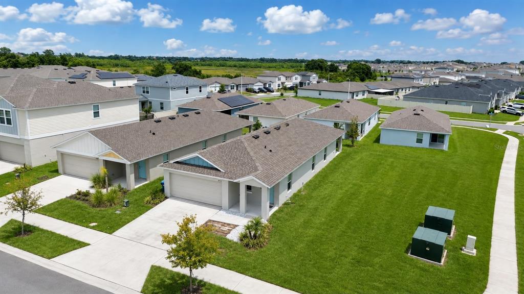 An aerial view shows several suburban houses with gray roofs and green lawns — 4904 MAINSAIL STREET, HAINES CITY, FL