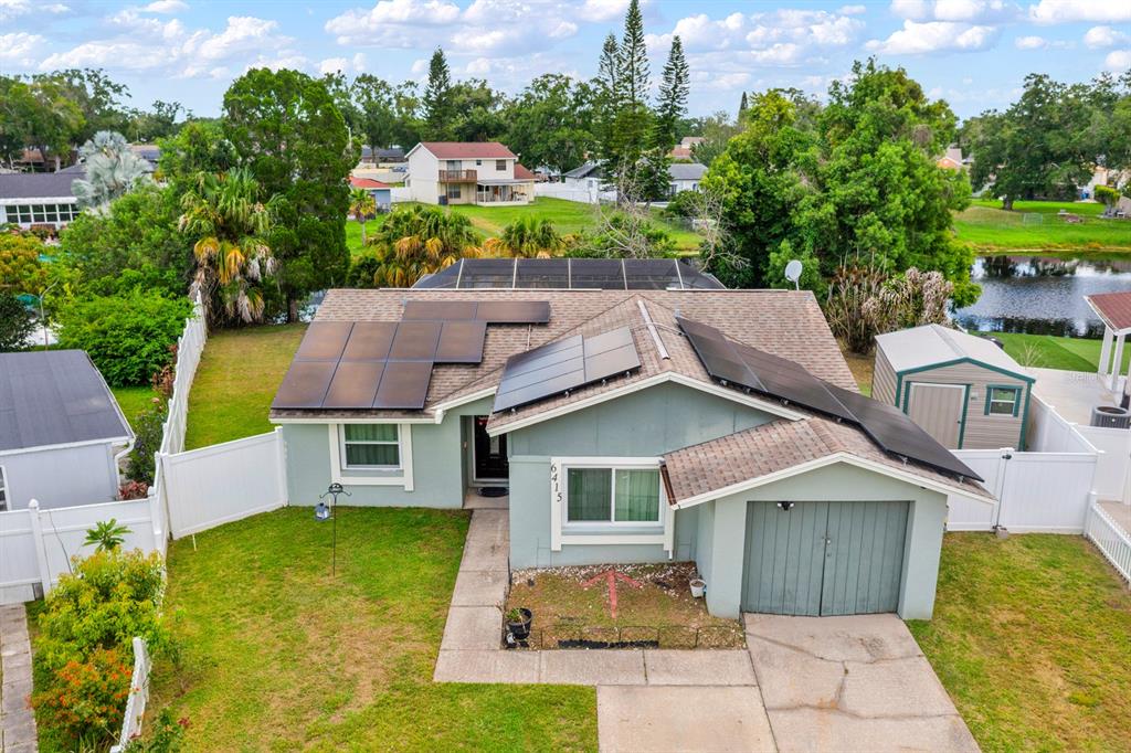 An aerial view of a single-story house with solar panels on the roof and yard — 6415 MONTEREY BOULEVARD, TAMPA, FL
