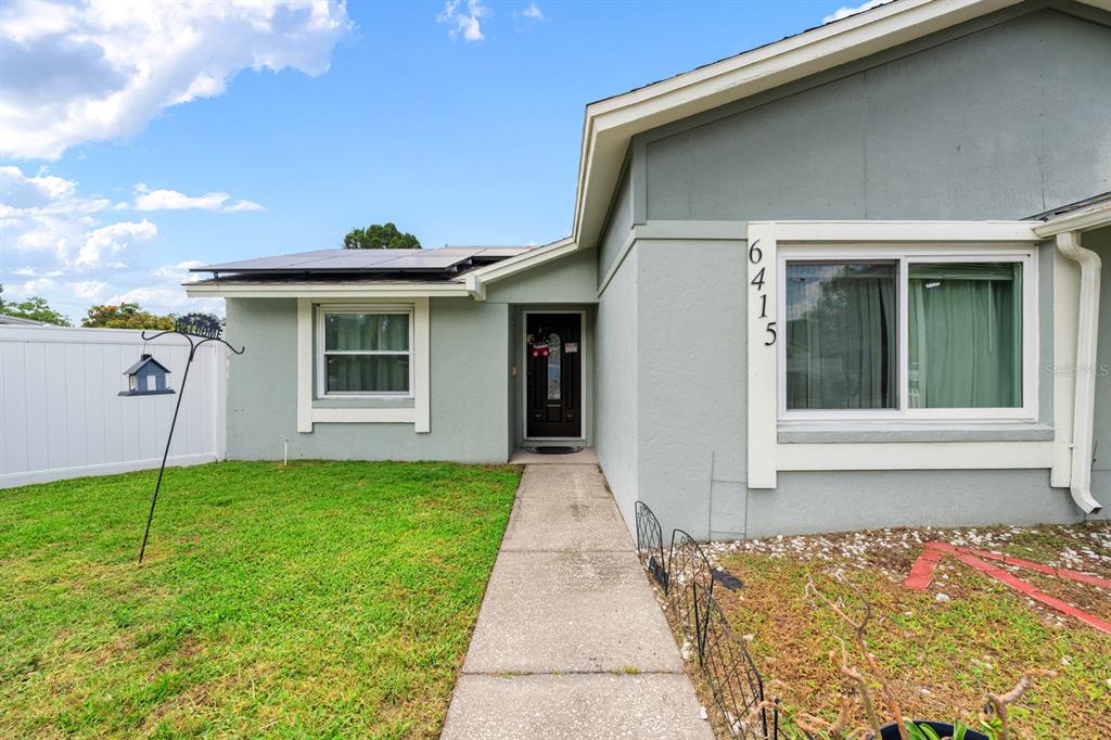 An entryway features a dark front door, a tall shoe rack, and wall-mounted children's toys — 6415 MONTEREY BOULEVARD, TAMPA, FL