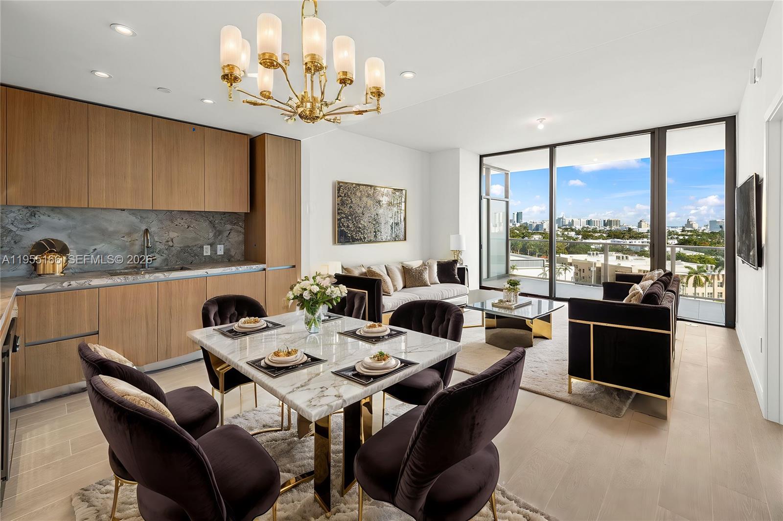 An open-concept living and dining area features marble surfaces, dark velvet furniture, and floor-to-ceiling windows — 500 Alton Rd # 908, Miami Beach FL 33139, MIAMI BEACH, FL