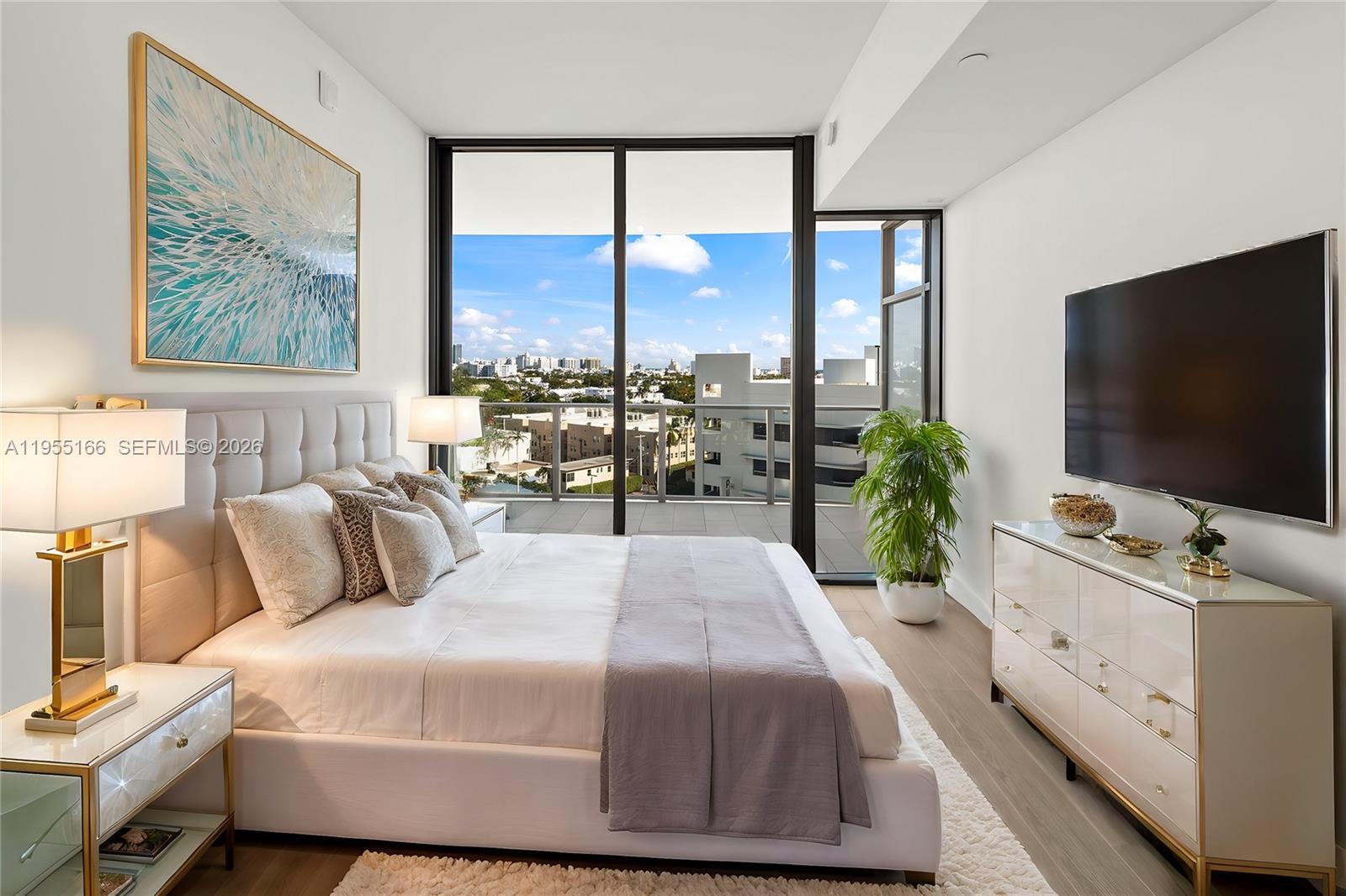 A modern bedroom features a king bed, a dresser, and a balcony with city views — 500 Alton Rd # 908, Miami Beach FL 33139, MIAMI BEACH, FL