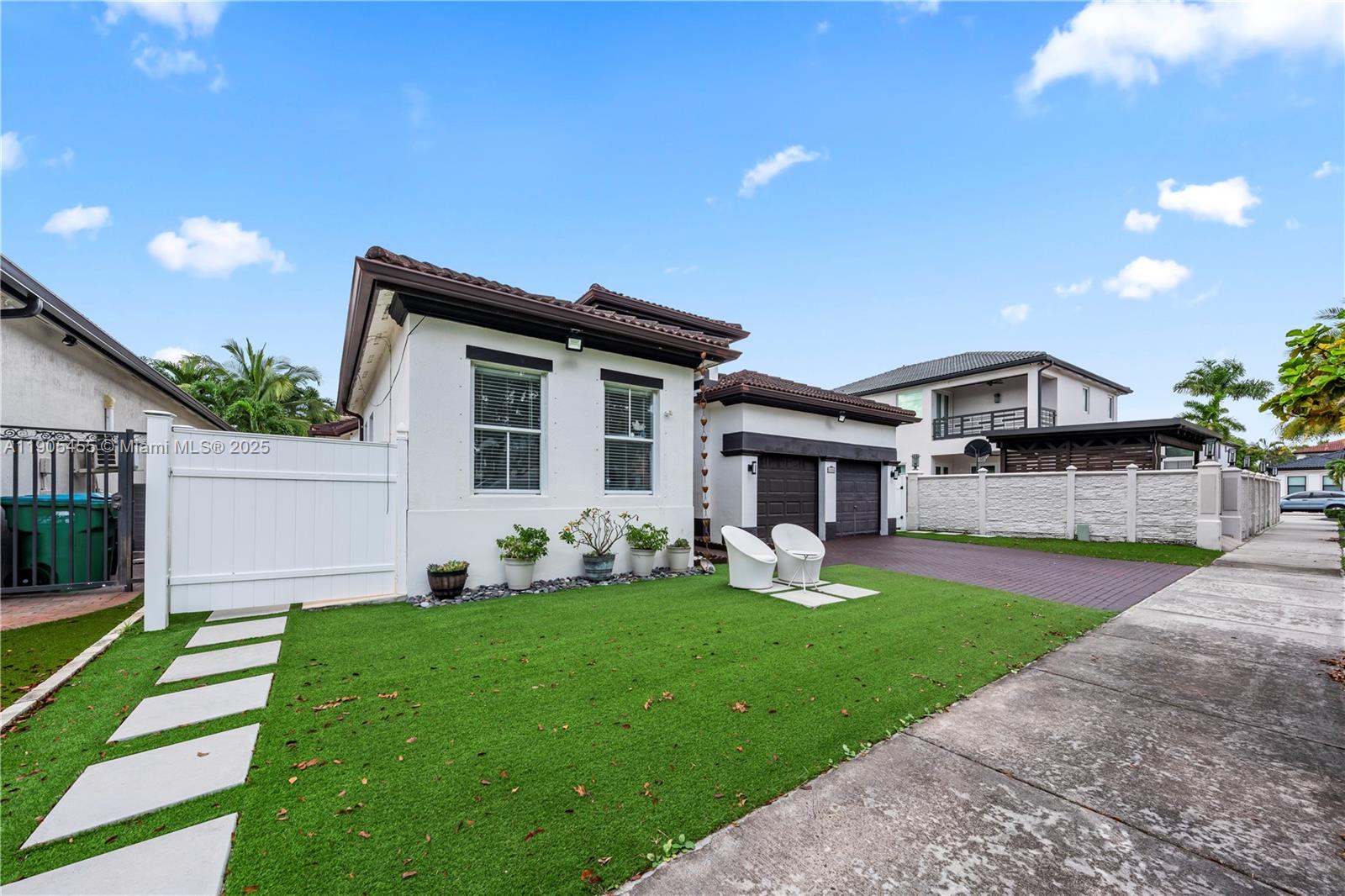 A white house with a green lawn, a paved driveway, and a white fence — 18000 NW 90th Pl, Hialeah FL 33018, HIALEAH, FL
