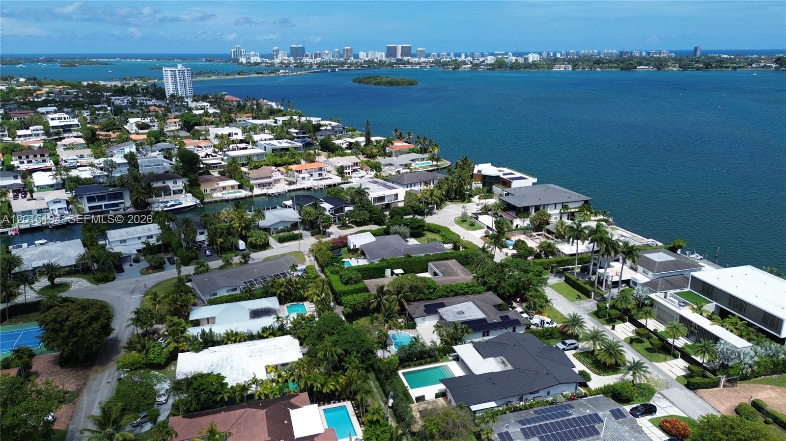 An aerial view shows several waterfront homes with swimming pools and lush landscaping — 11445 N Bayshore Dr, North Miami FL 33181, NORTH MIAMI, FL