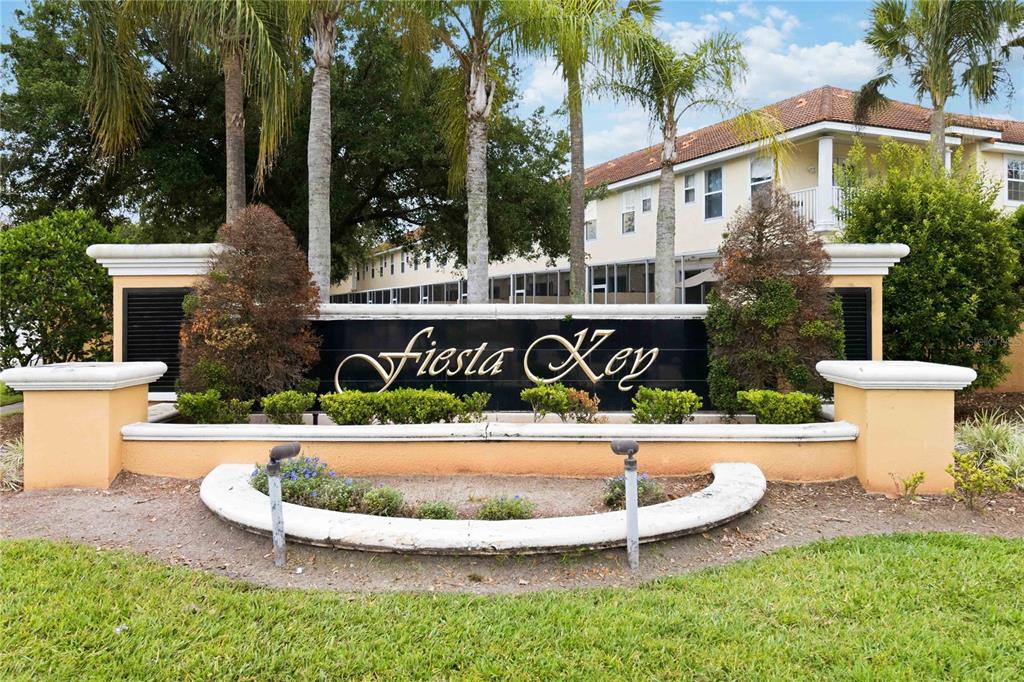 A sign for Fiesta Key stands in front of a multi-story apartment building with palm trees — 4729 CORAL CASTLE DRIVE, KISSIMMEE, FL