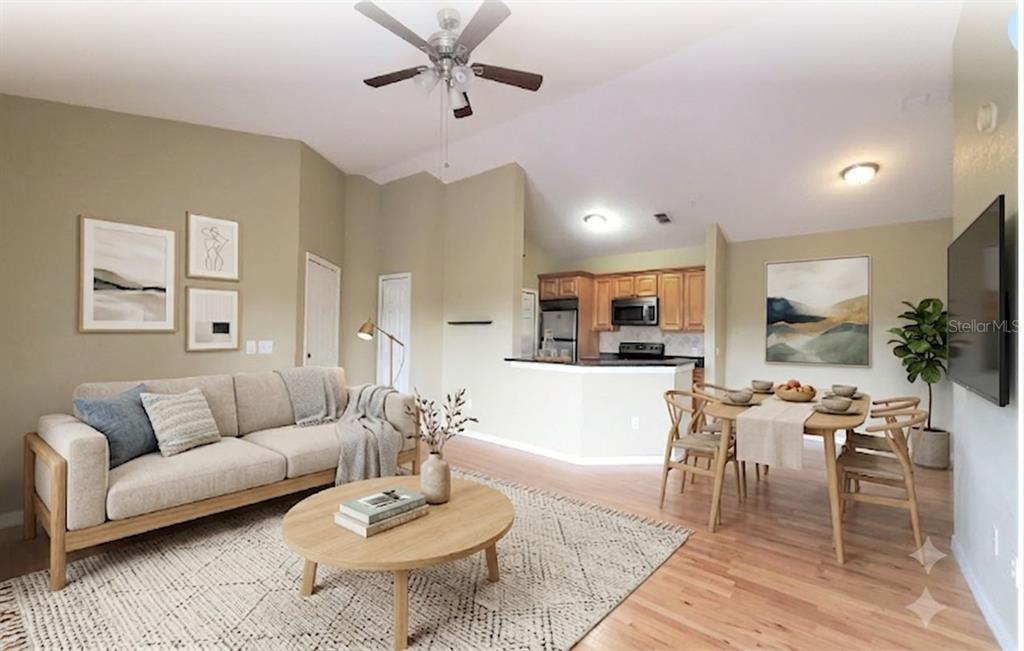 A living room and dining area with light wood floors, neutral walls, and vaulted ceilings — 5959 WESTGATE DRIVE UNIT 1535, ORLANDO, FL