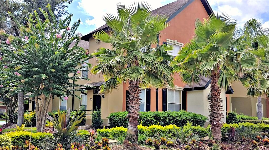 A two-story tan and orange building features palm trees and landscaping in the front yard — 5959 WESTGATE DRIVE UNIT 1535, ORLANDO, FL