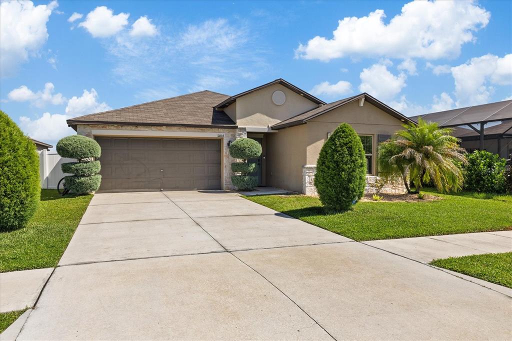 A single-story house with a two-car garage, stone accents, and a landscaped front yard — 11803 BLACKEYED SUSAN DRIVE, RIVERVIEW, FL