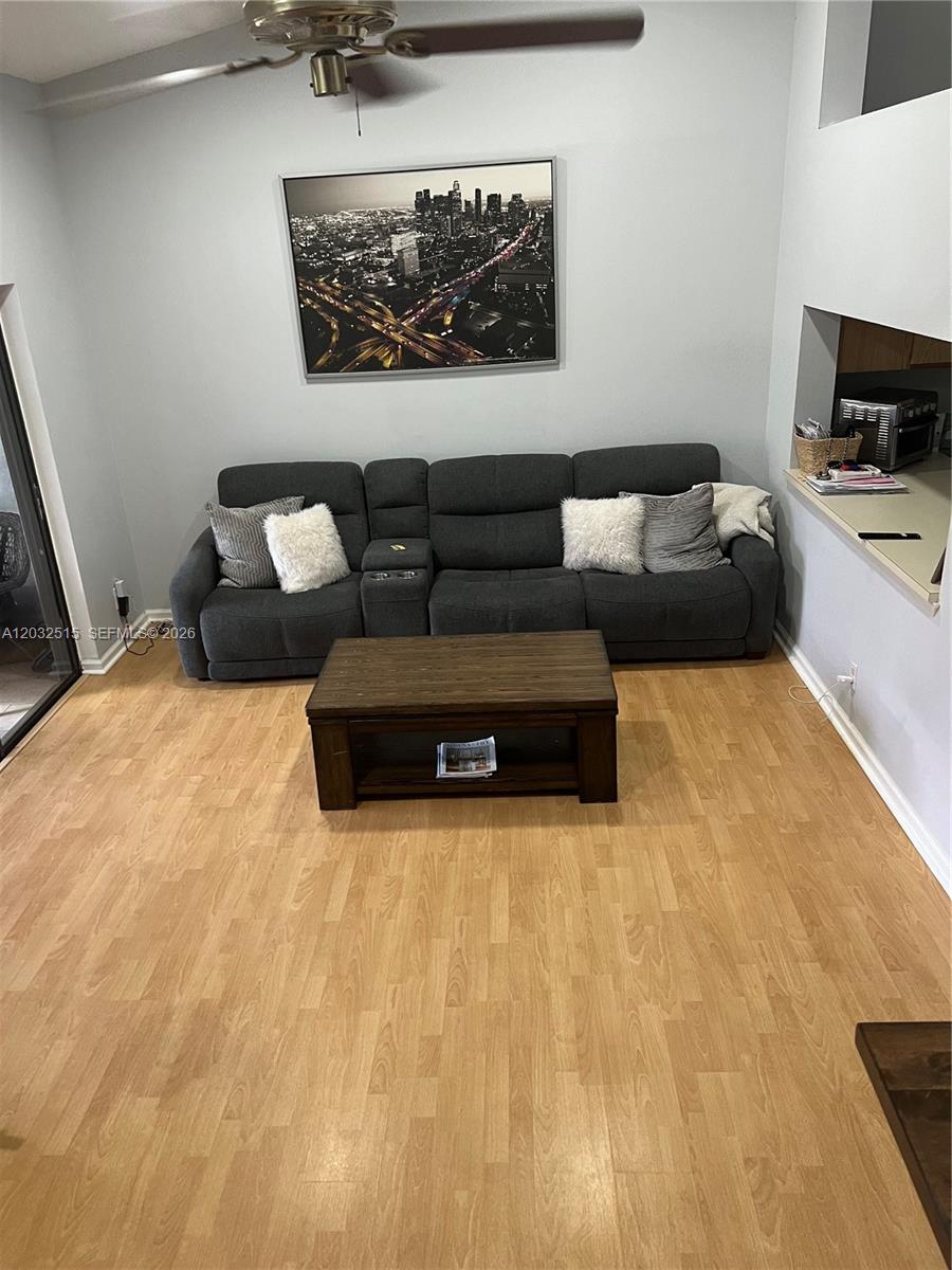 A living room features a gray reclining sofa, a wooden coffee table, and light flooring — 306 Republic Ct # 306, Deerfield Beach FL 33442, DEERFIELD BEACH, FL