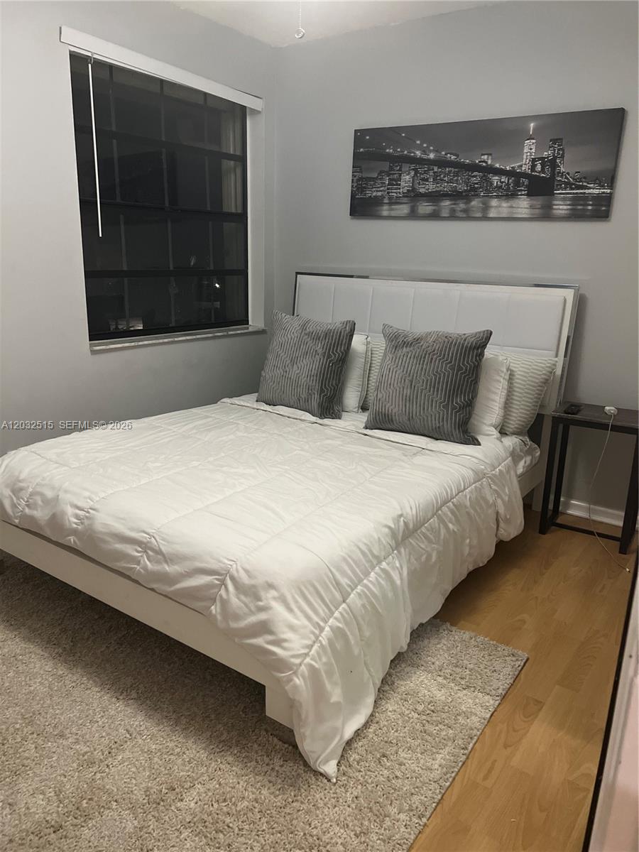 A bedroom features a white bed with gray accent pillows, a window, and wall art — 306 Republic Ct # 306, Deerfield Beach FL 33442, DEERFIELD BEACH, FL