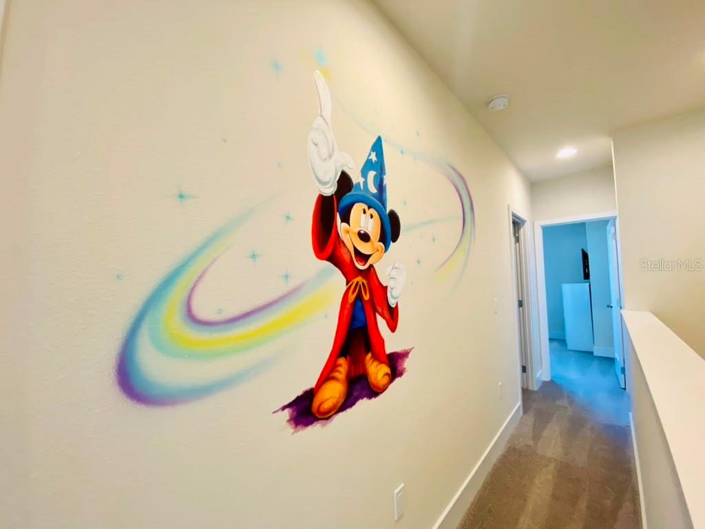 A hallway features a large mural of Sorcerer Mickey Mouse painted on the wall — 17214 BLESSING DRIVE, CLERMONT, FL