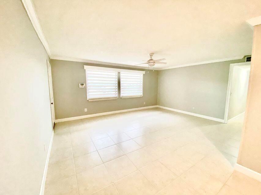 An empty room features light-colored tile flooring, gray walls, and a ceiling fan — 3303 Kirk Road # 1, Lake Worth FL 33461, LAKE WORTH, FL
