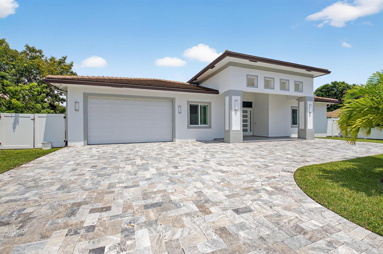 A single-story house with a white exterior, a paved driveway, and a two-car garage — 711 NE 6th Street, Boca Raton FL 33432, BOCA RATON, FL