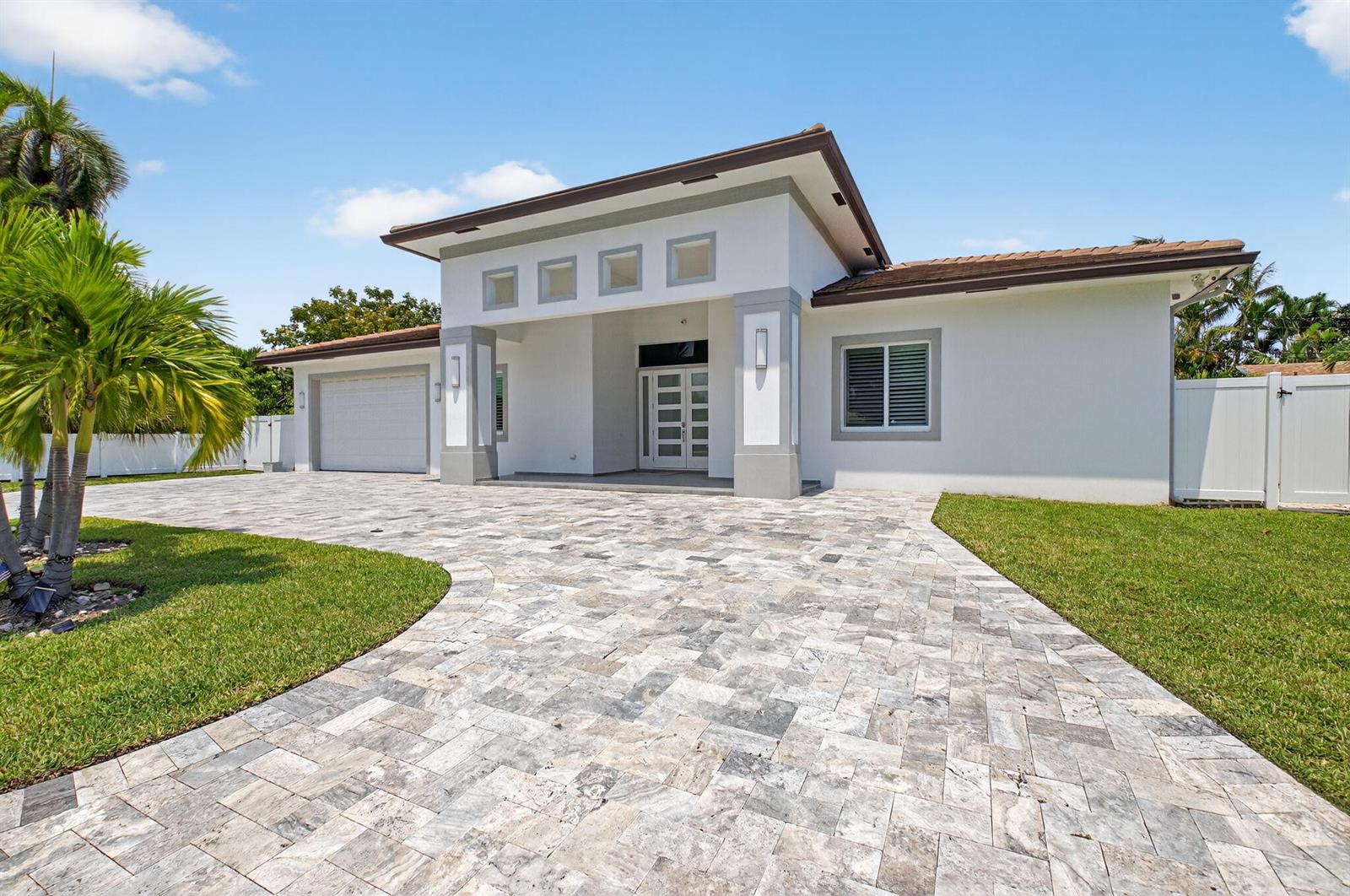 A single-story house with a white exterior, gray trim, and a paved stone driveway — 711 NE 6th Street, Boca Raton FL 33432, BOCA RATON, FL