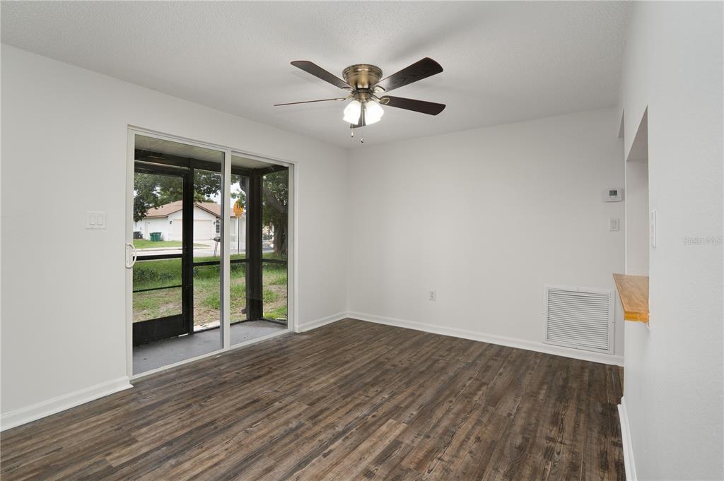 An empty room with wood-look flooring, a ceiling fan, and a sliding glass door — 22291 WESTCHESTER BOULEVARD UNIT 301, PORT CHARLOTTE, FL