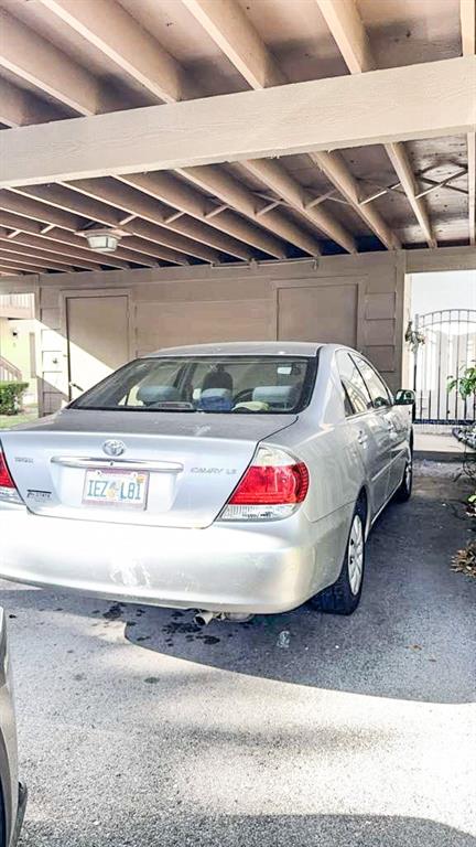 A silver Toyota Camry is parked under a covered carport attached to a building — 12922 WEDGEWOOD WAY UNIT A, HUDSON, FL