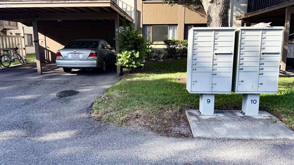 A silver sedan is parked under a carport next to two outdoor metal mailbox units — 12922 WEDGEWOOD WAY UNIT A, HUDSON, FL