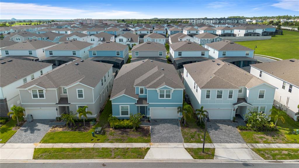 An aerial view shows a row of suburban houses with paved driveways and green lawns — 3625 LILY LANE, DAVENPORT, FL