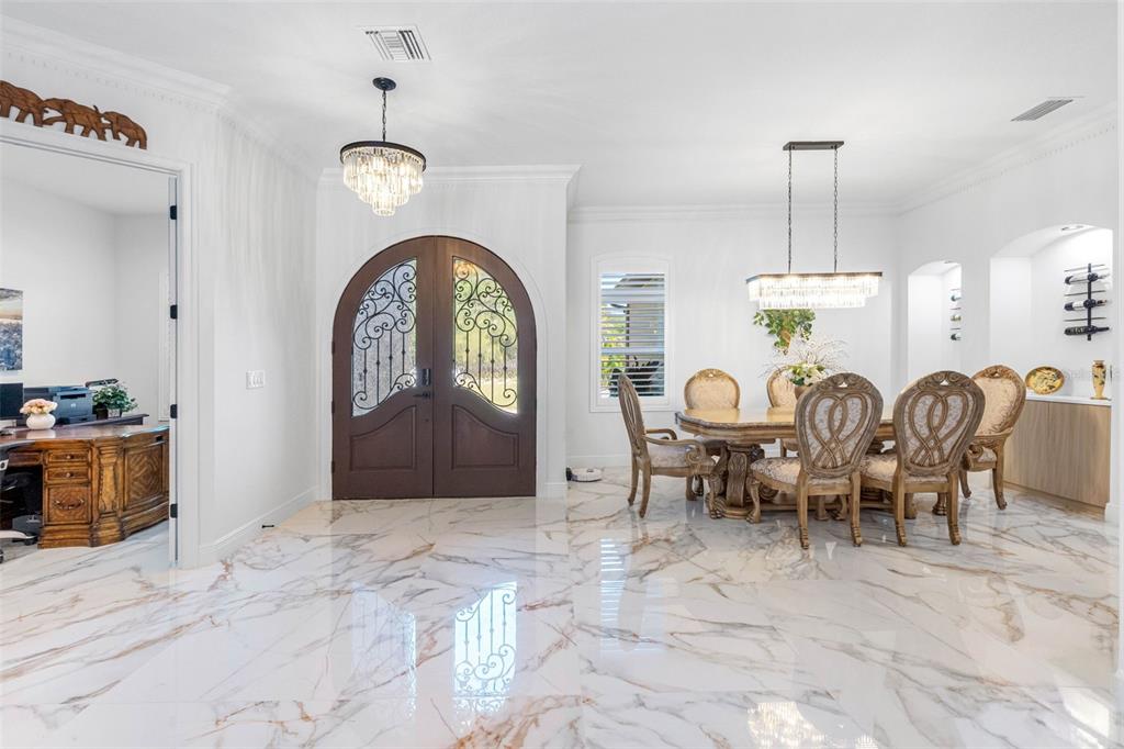A dining area and entryway feature white marble floors, a crystal chandelier, and arched doors — 17117 LAKESHORE ROAD, LUTZ, FL