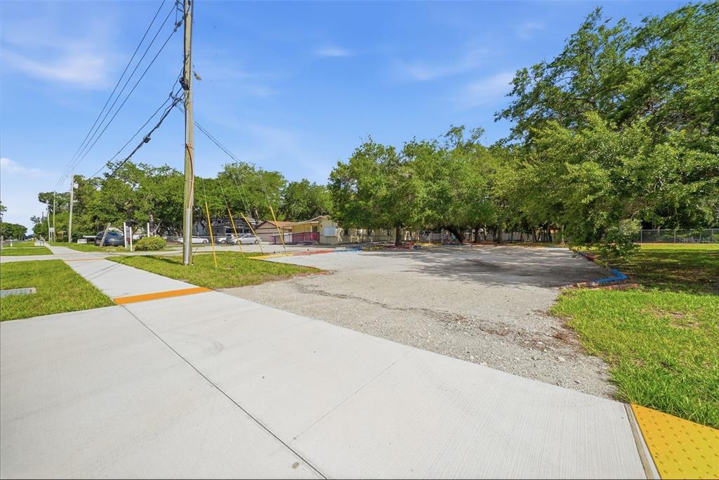 A paved driveway leads to a small yellow building surrounded by trees and grass — 2886 WHITNEY ROAD, CLEARWATER, FL