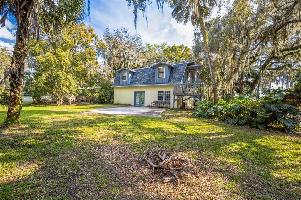 A two-story house with a yellow exterior, a gray shingled roof, and a wooden deck — 9401 CAT TRACK TRAIL, LAKE WALES, FL