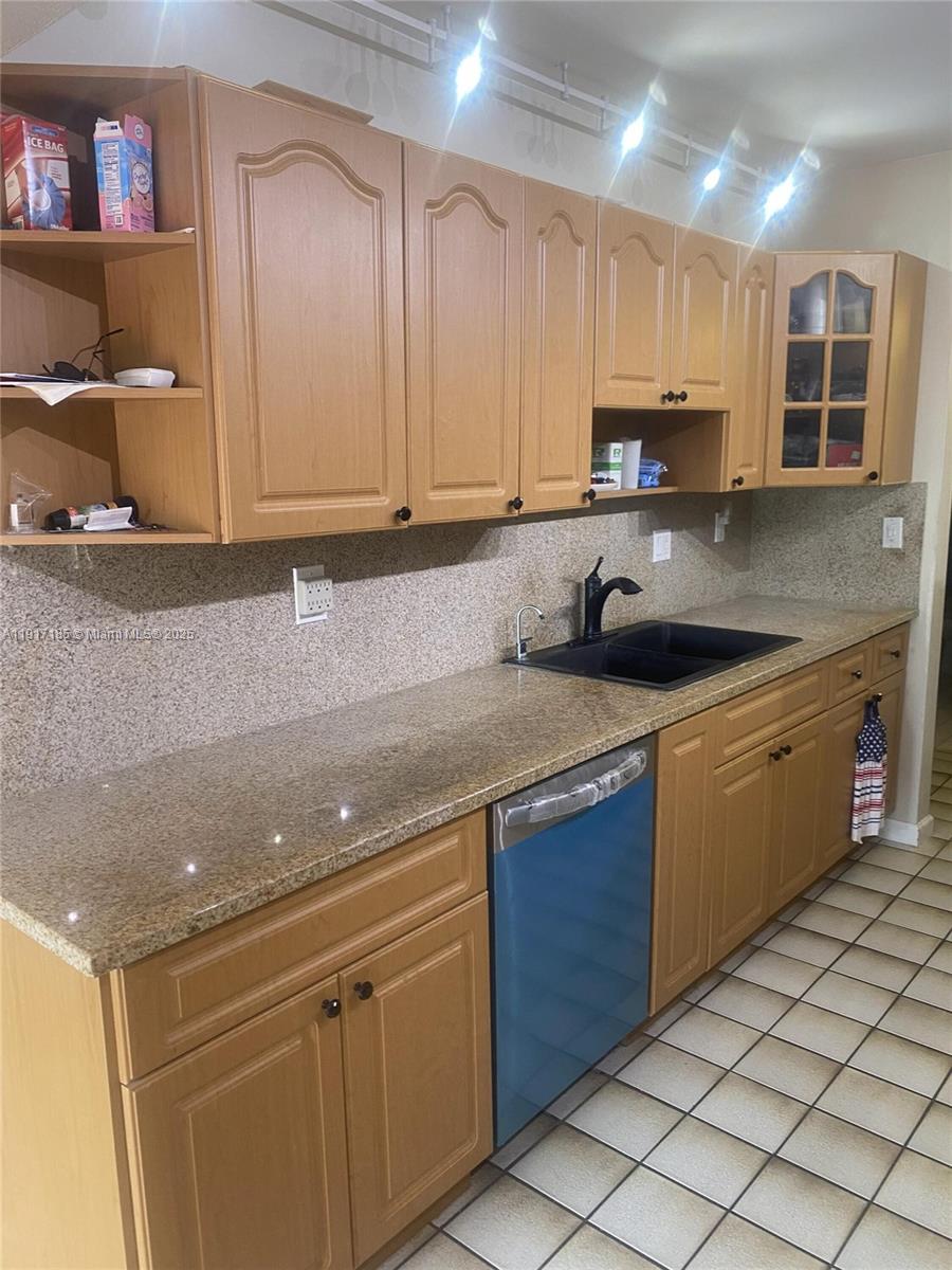 A kitchen features light wood cabinets, granite countertops, a black sink, and tiled flooring — 4802 Bayberry Ln, Tamarac FL 33319, TAMARAC, FL
