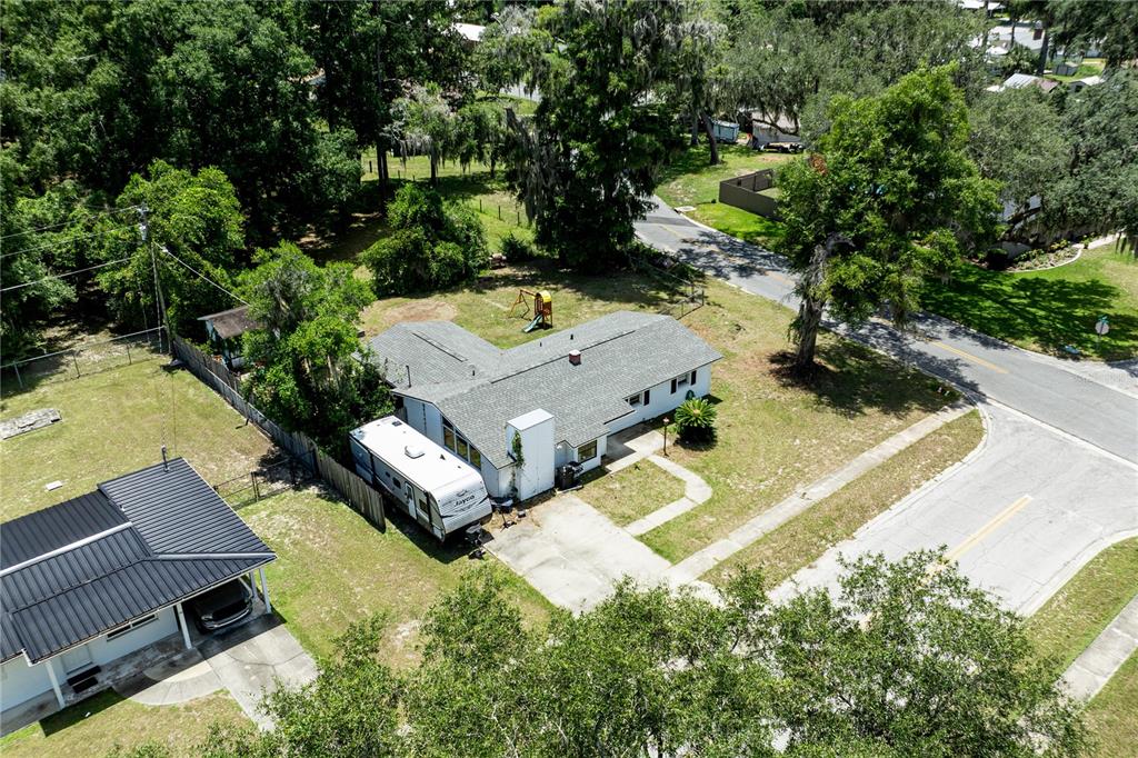 An aerial view shows a single-story house with a gray roof, a driveway, and a camper — 294 SE TRIBBLE STREET, LAKE CITY, FL