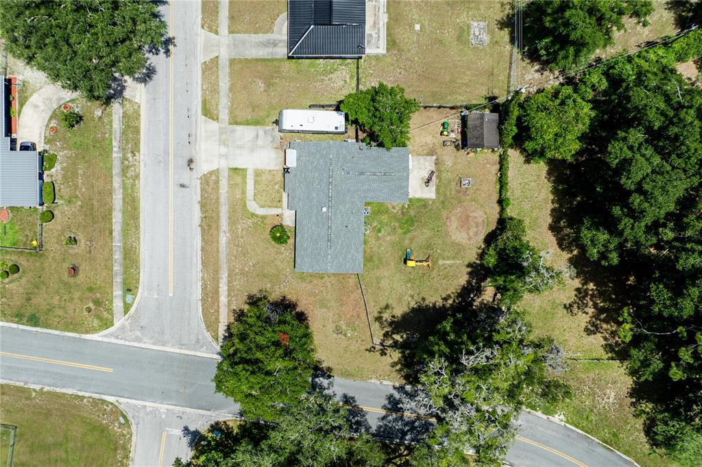 An aerial view shows a house with a gray roof, a driveway, and a backyard — 294 SE TRIBBLE STREET, LAKE CITY, FL