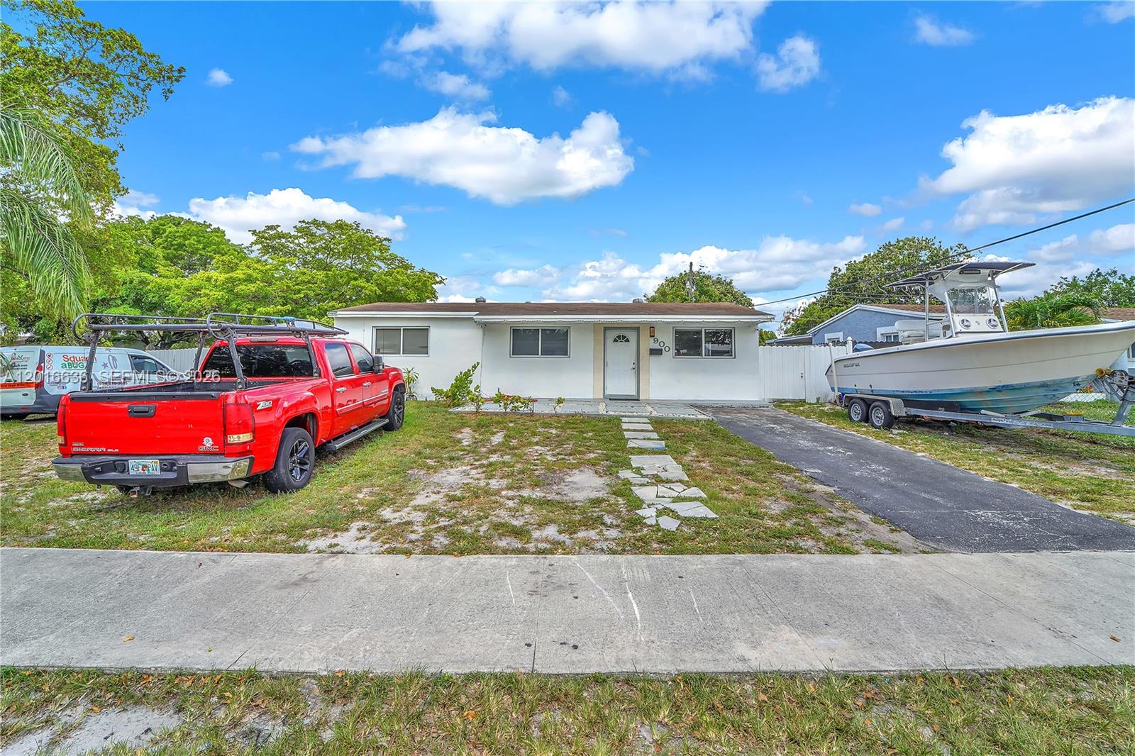 A single-story white house features a red pickup truck and a boat parked in front — 900 N 70th Ave, Hollywood FL 33024, HOLLYWOOD, FL