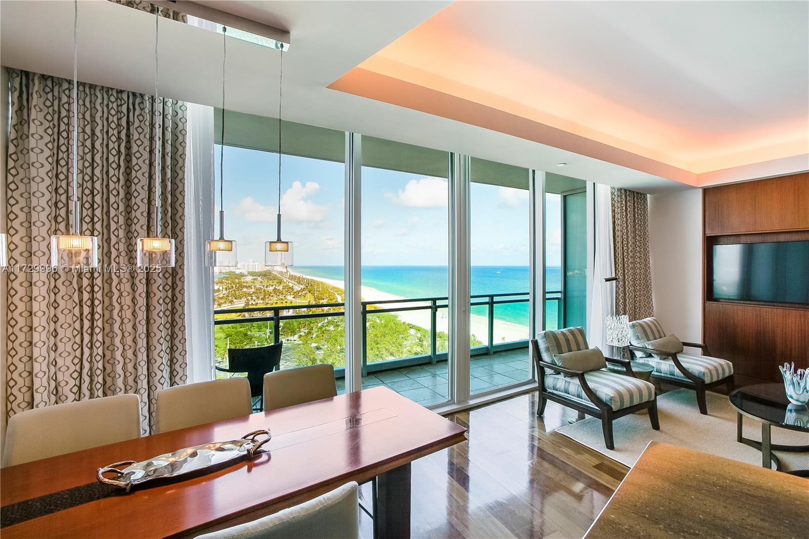A dining area and living space feature floor-to-ceiling windows overlooking the ocean and beach — 10295 Collins Ave, Bal Harbour FL 33154, BAL HARBOUR, FL