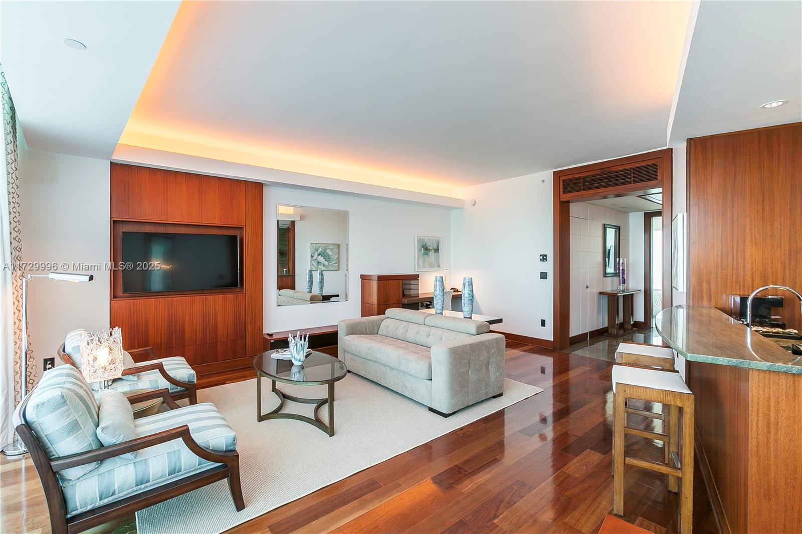 A living room features wood paneling, hardwood floors, a sofa, two armchairs, and a bar — 10295 Collins Ave, Bal Harbour FL 33154, BAL HARBOUR, FL