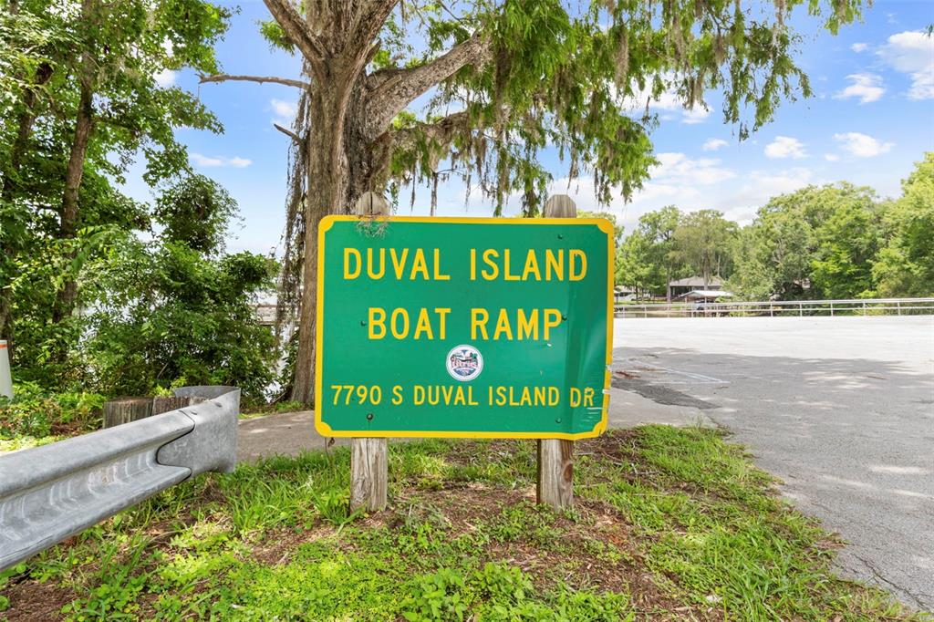 A green sign for a boat ramp stands outdoors near a paved road and trees — 11420 E STEAMBOAT DRIVE, FLORAL CITY, FL
