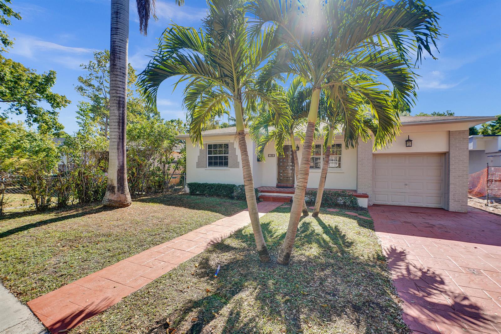 A single-story house with a red paved driveway, walkway, and palm trees in the front yard — 130 NE 49th Street, Miami FL 33137, MIAMI, FL