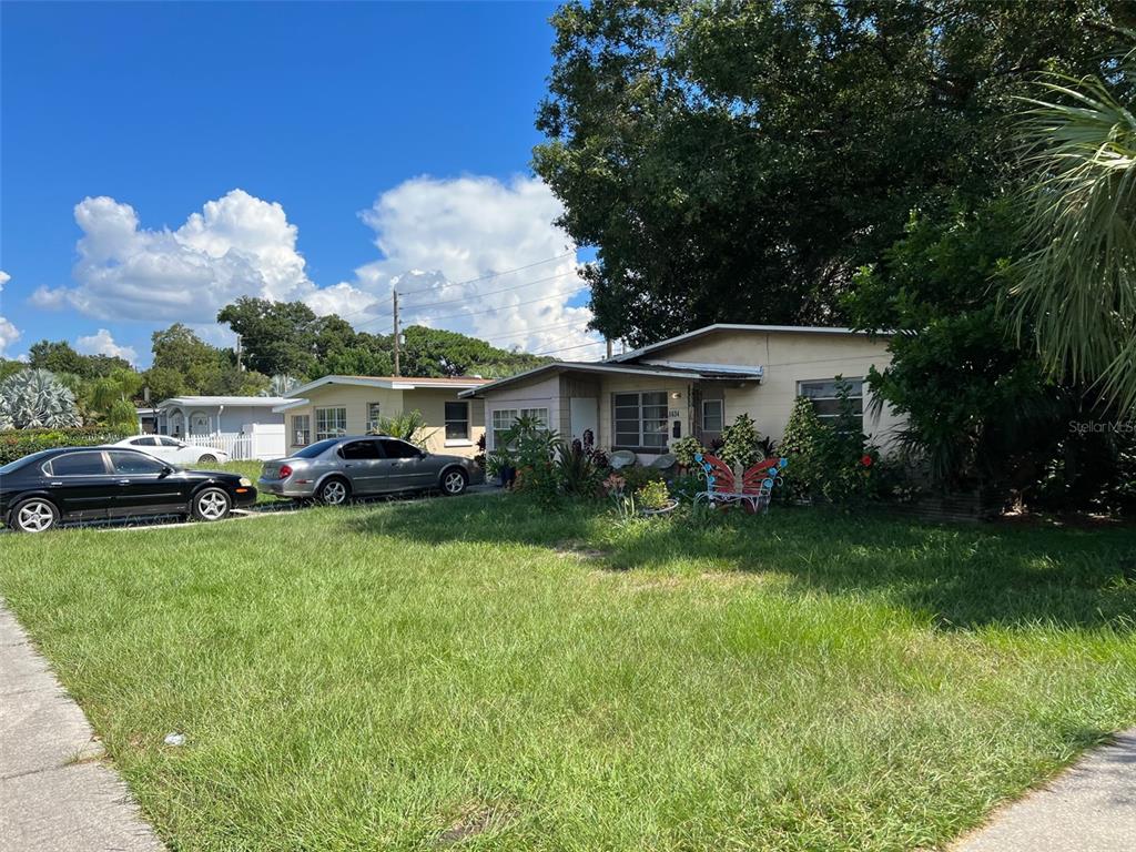 A single-story house with a grassy front yard and two parked cars in the driveway — 5634 5TH AVENUE N, ST PETERSBURG, FL