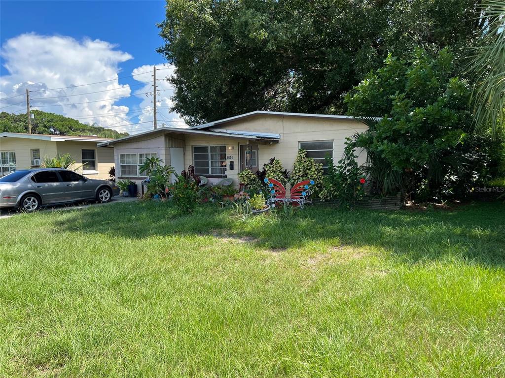 A single-story house with a beige exterior, a metal roof, and a front yard — 5634 5TH AVENUE N, ST PETERSBURG, FL