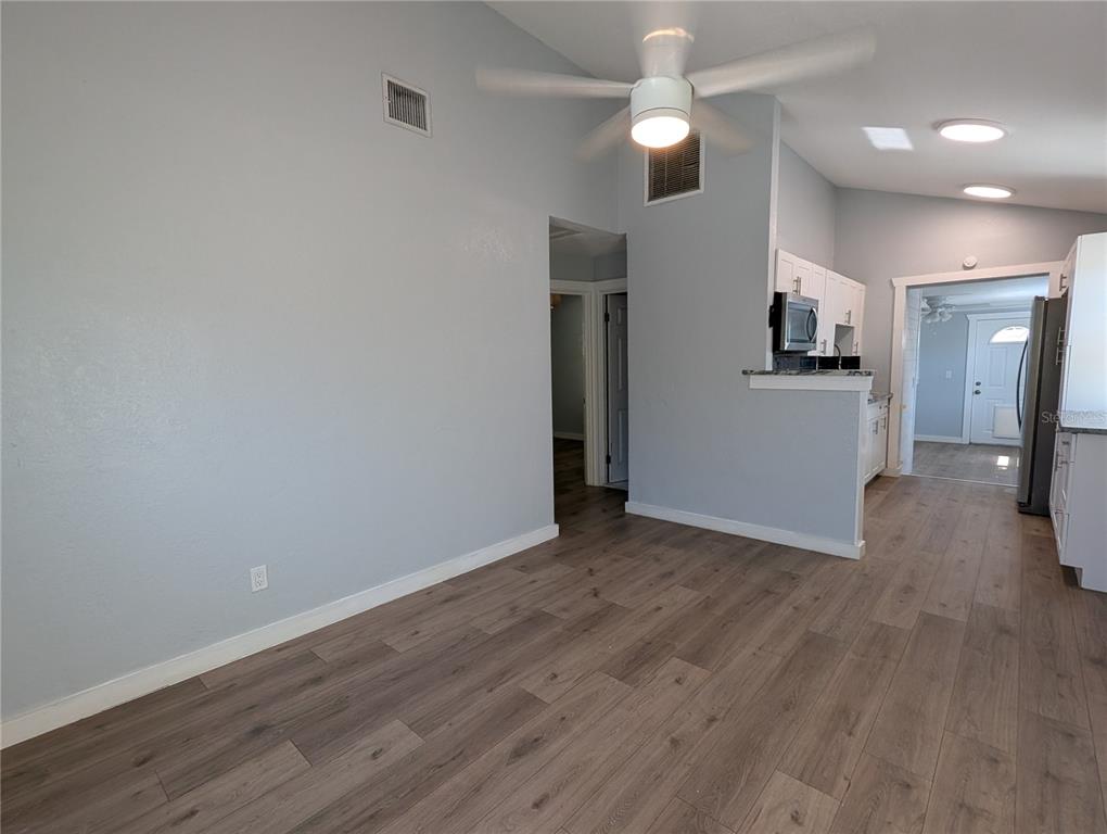 A living area with light gray walls, wood-look flooring, and a ceiling fan — 5005 NEWTON AVENUE S, GULFPORT, FL