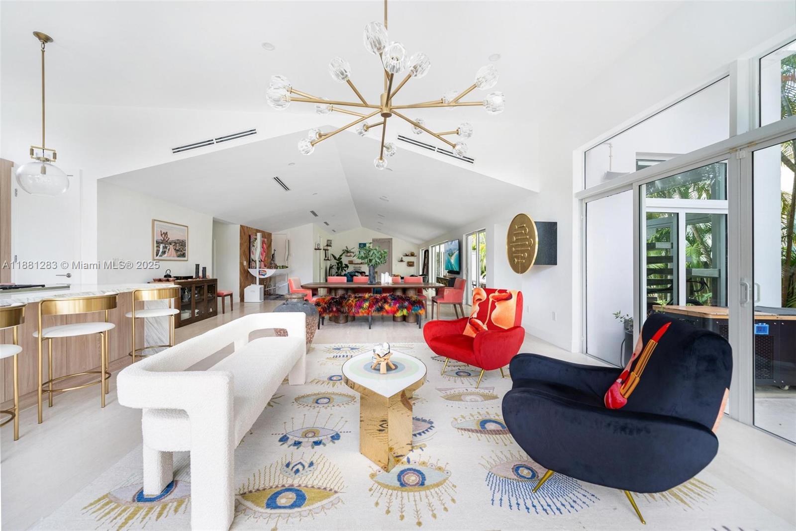 A bright, open-concept living and dining area features a vaulted ceiling and modern decor — 520 E Dilido Dr, Miami Beach FL 33139, MIAMI BEACH, FL