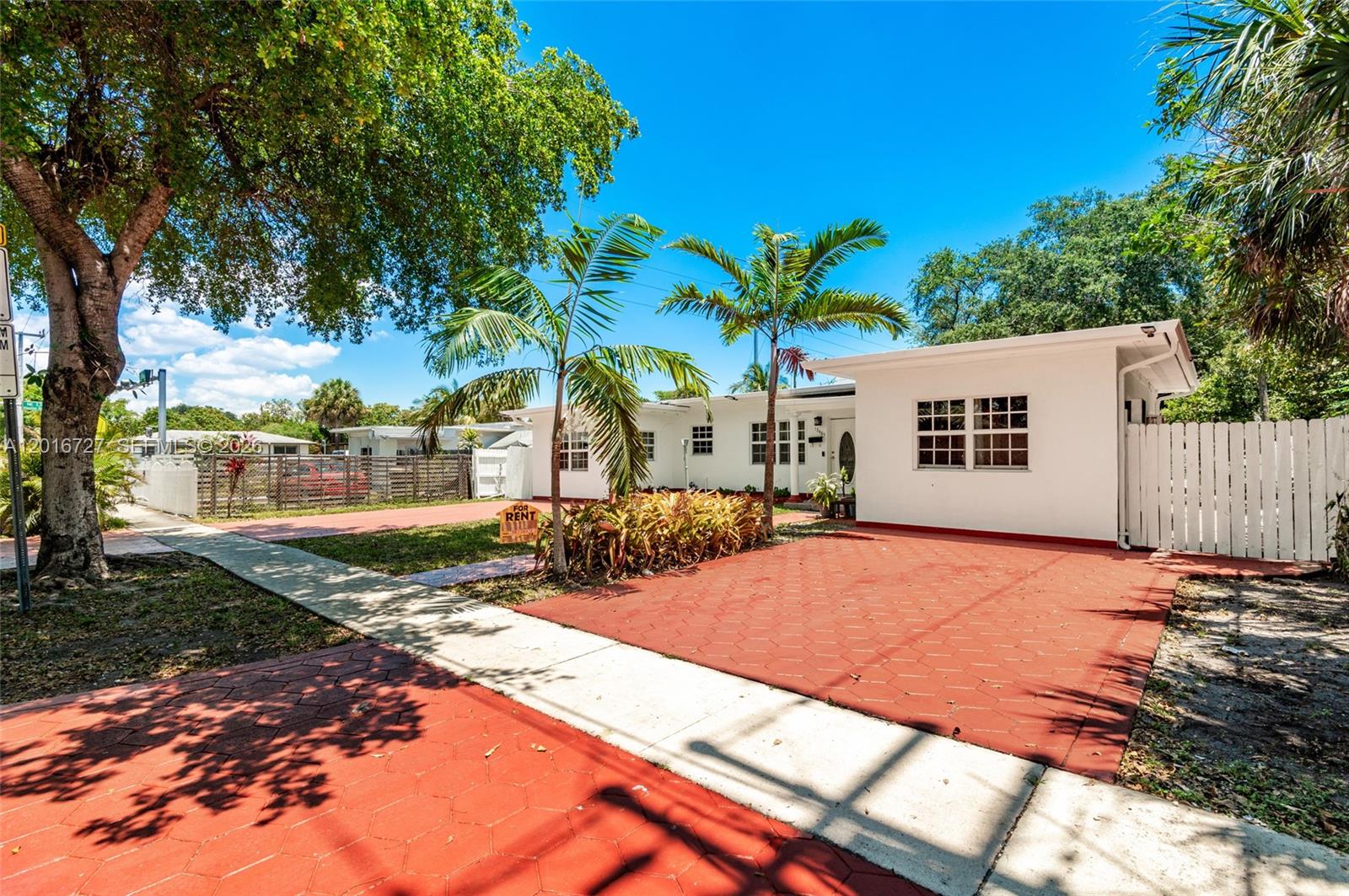 A white single-story house features a red paved driveway and palm trees in the front yard — 13485 NE 9th Ave, North Miami FL 33161, NORTH MIAMI, FL