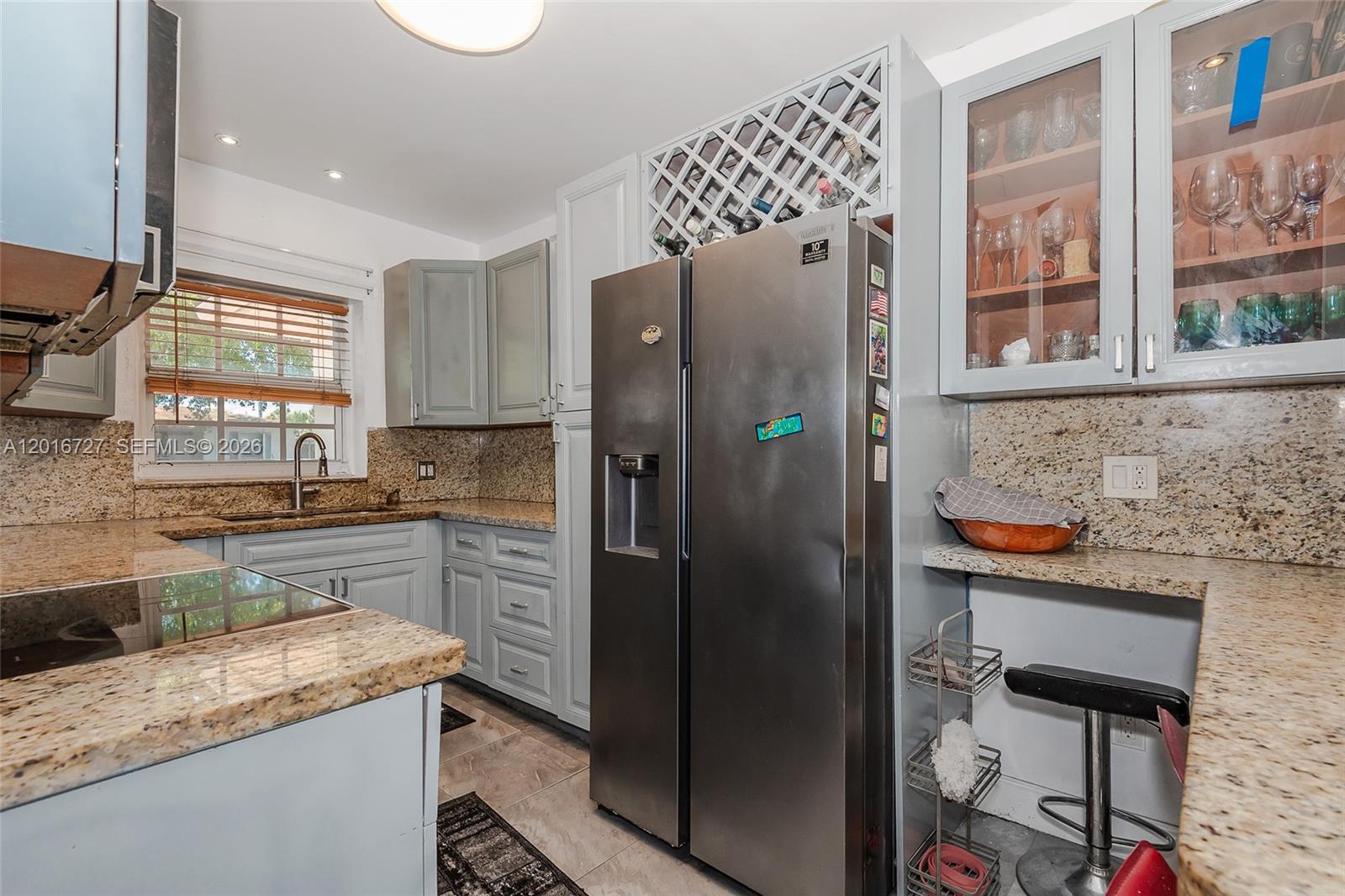 A kitchen features light gray cabinets, granite countertops, stainless steel appliances, and a wine rack — 13485 NE 9th Ave, North Miami FL 33161, NORTH MIAMI, FL