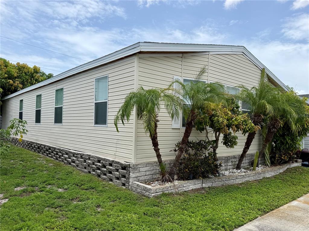 A beige mobile home with horizontal siding and a concrete block foundation wall — 34066 AVOCADO DRIVE N, PINELLAS PARK, FL
