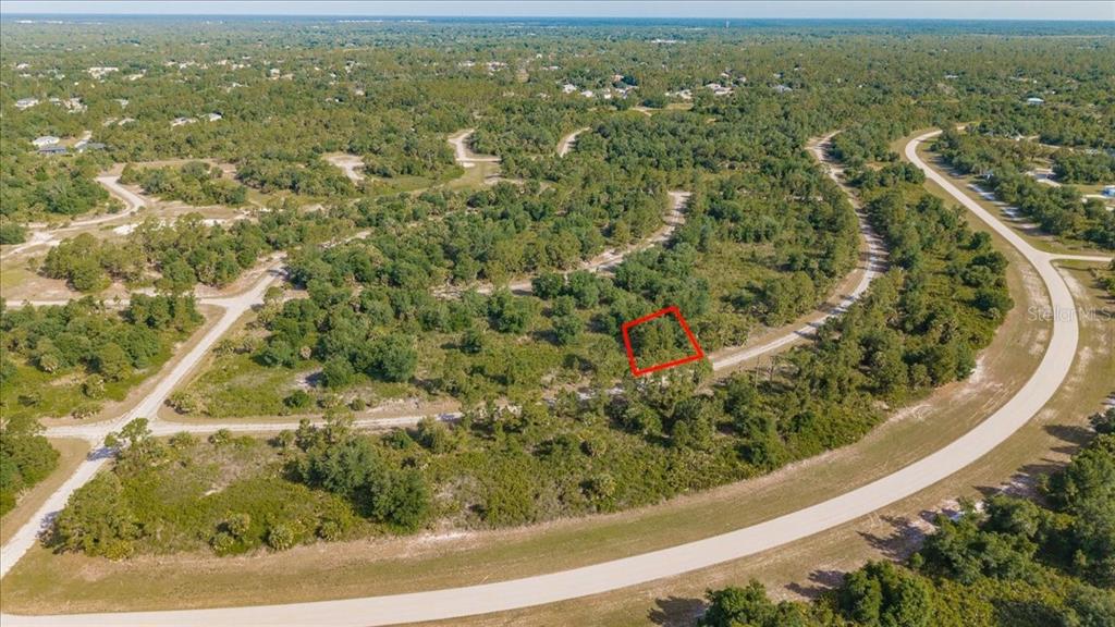 An aerial view of a vacant, wooded lot outlined in red within a residential subdivision — WINTERVILLE CIRCLE, NORTH PORT, FL