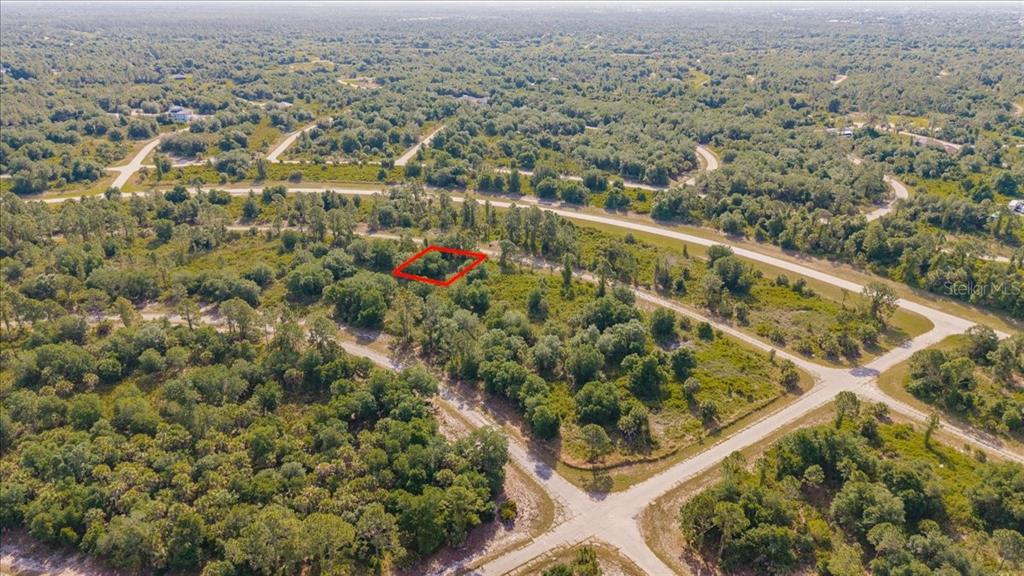An aerial view shows a vacant, wooded lot outlined in red within a residential subdivision — WINTERVILLE CIRCLE, NORTH PORT, FL
