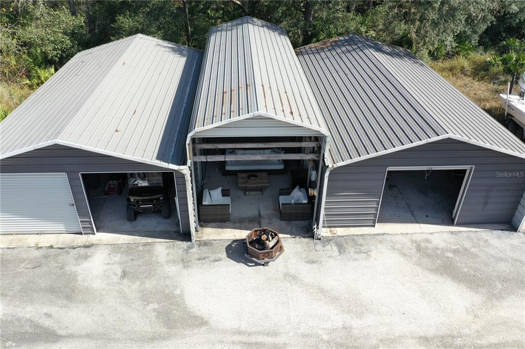 An aerial view shows a three-bay metal structure with a central open-air lounge area — 4125 TIGER CREEK TRL, LAKE WALES, FL