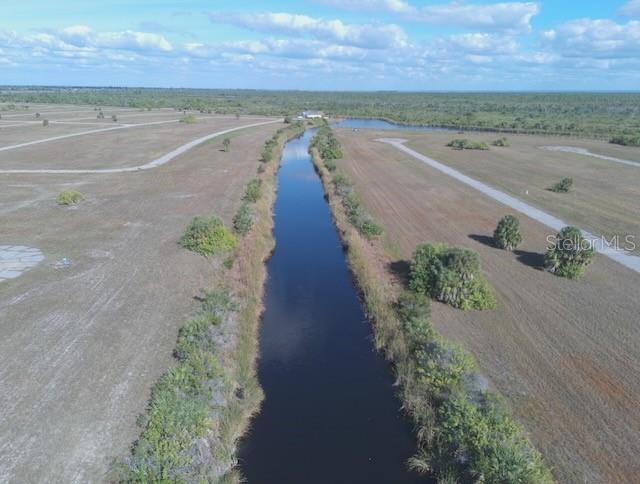 An aerial view shows a narrow canal running through a flat, undeveloped grassy landscape — 14381 KING PHILLIP COURT, PLACIDA, FL