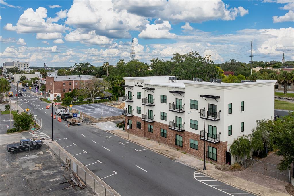 The exterior of a three-story brick and white stucco apartment building with balconies — 419 SE 1ST AVENUE UNIT 201, OCALA, FL