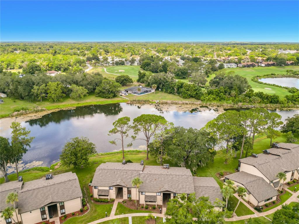 An aerial view shows multi-unit residential buildings situated beside a lake and a golf course — 655 MIDWAY DRIVE UNIT A, OCALA, FL