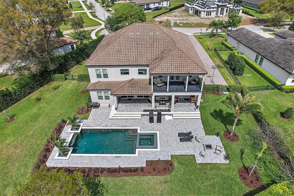 An aerial view of a two-story house with a pool, spa, and paved patio area — 25868 CROSSINGS BLUFF LANE, SORRENTO, FL
