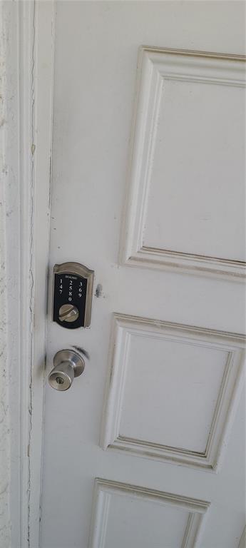 A white door features a silver electronic keypad lock and a standard round door knob — 3813 N OAK DRIVE UNIT F12, TAMPA, FL